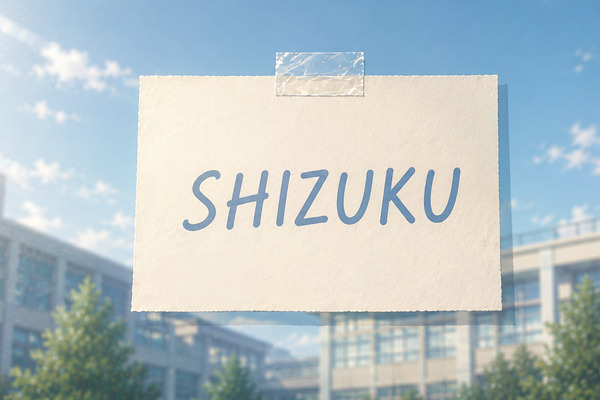 ガラスに貼られた「SHIZUKU」と書かれた紙に、横からの光が当たり細い影が伸びるイメージ